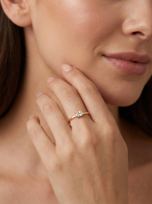 Mano de modelo luciendo el anillo fino Claire en oro de 18k, una joya sutil y elegante de la línea Pure.