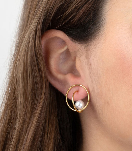 Primer plano del pendiente Nuvola puesto en la oreja, mostrando su tamaño y el efecto visual de la perla suspendida.