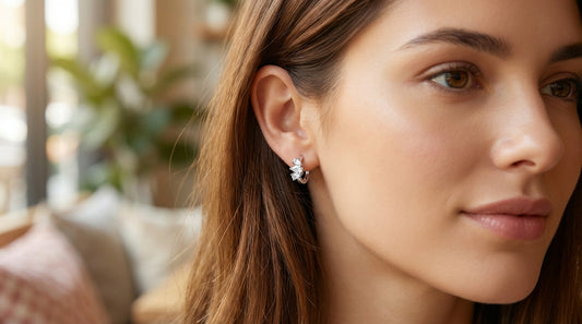 Modelo luciendo pendientes de aro pequeños de plata con circonitas blancas, ideales para primer o segundo agujero.