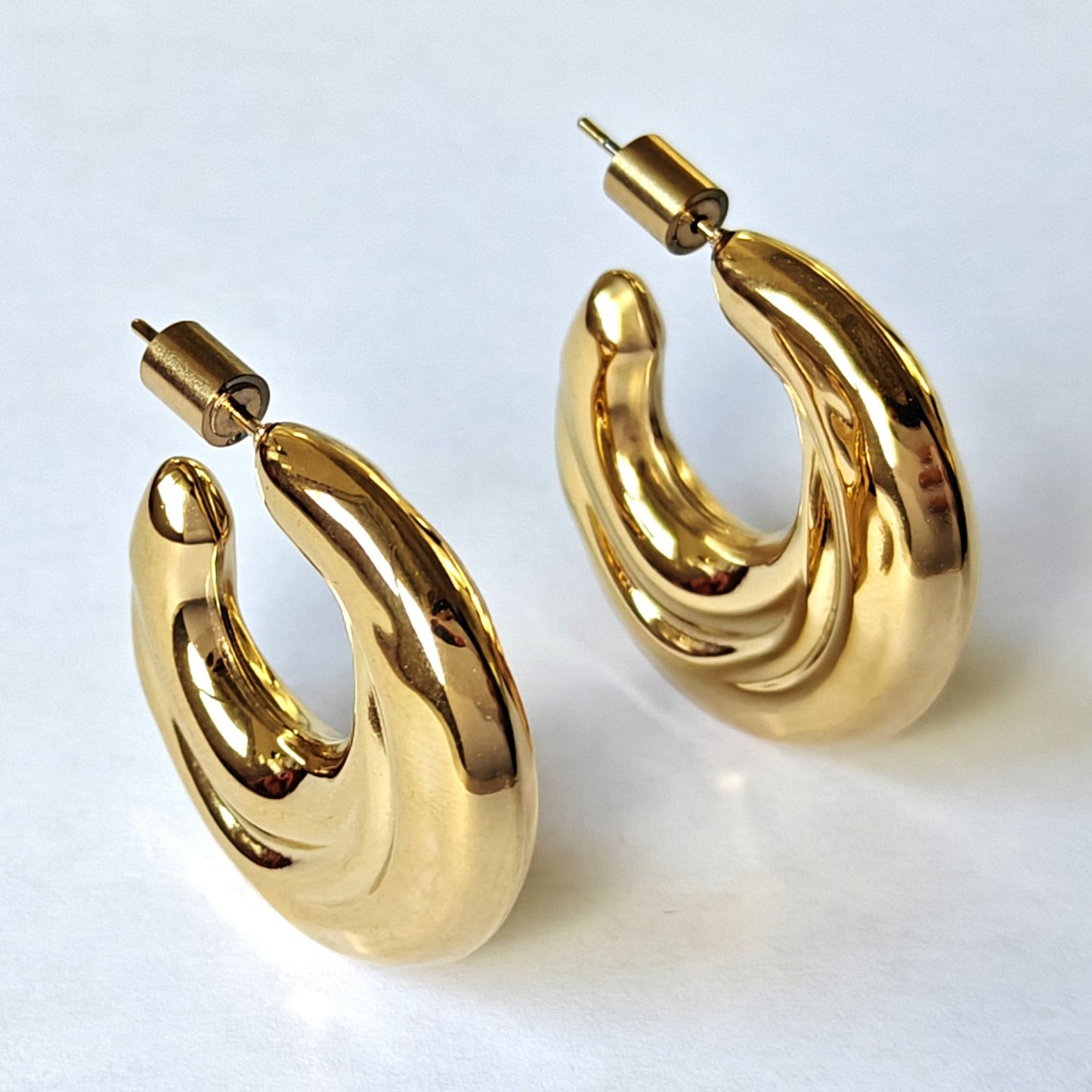 Vista lateral del par de pendientes SCIVOLA en oro 18K waterproof