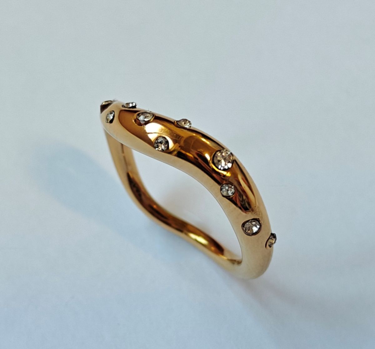 Detalle frontal del anillo Aere de la línea Vita en acero inoxidable waterproof con baño de oro de 18k y circonitas diseño esculpido orgánico de MALBAE.