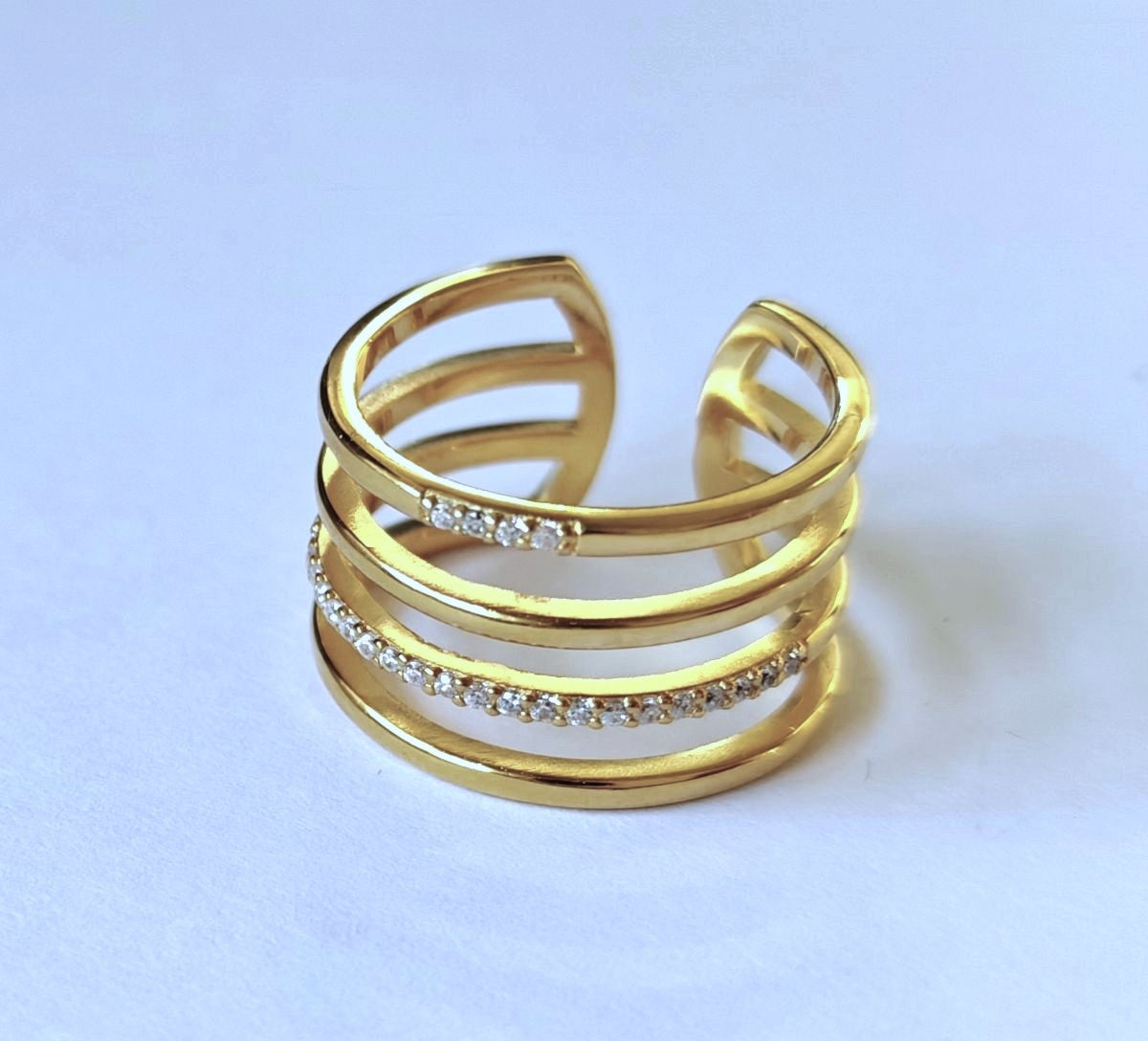 Detalle de anillo ajustable multicapa dorado fabricado en plata de ley 925 con un acabado de baño de oro de 18k.