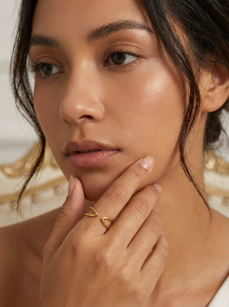 Mano de modelo luciendo el anillo ajustable Infini en acabado oro de 18k, joyería contemporánea