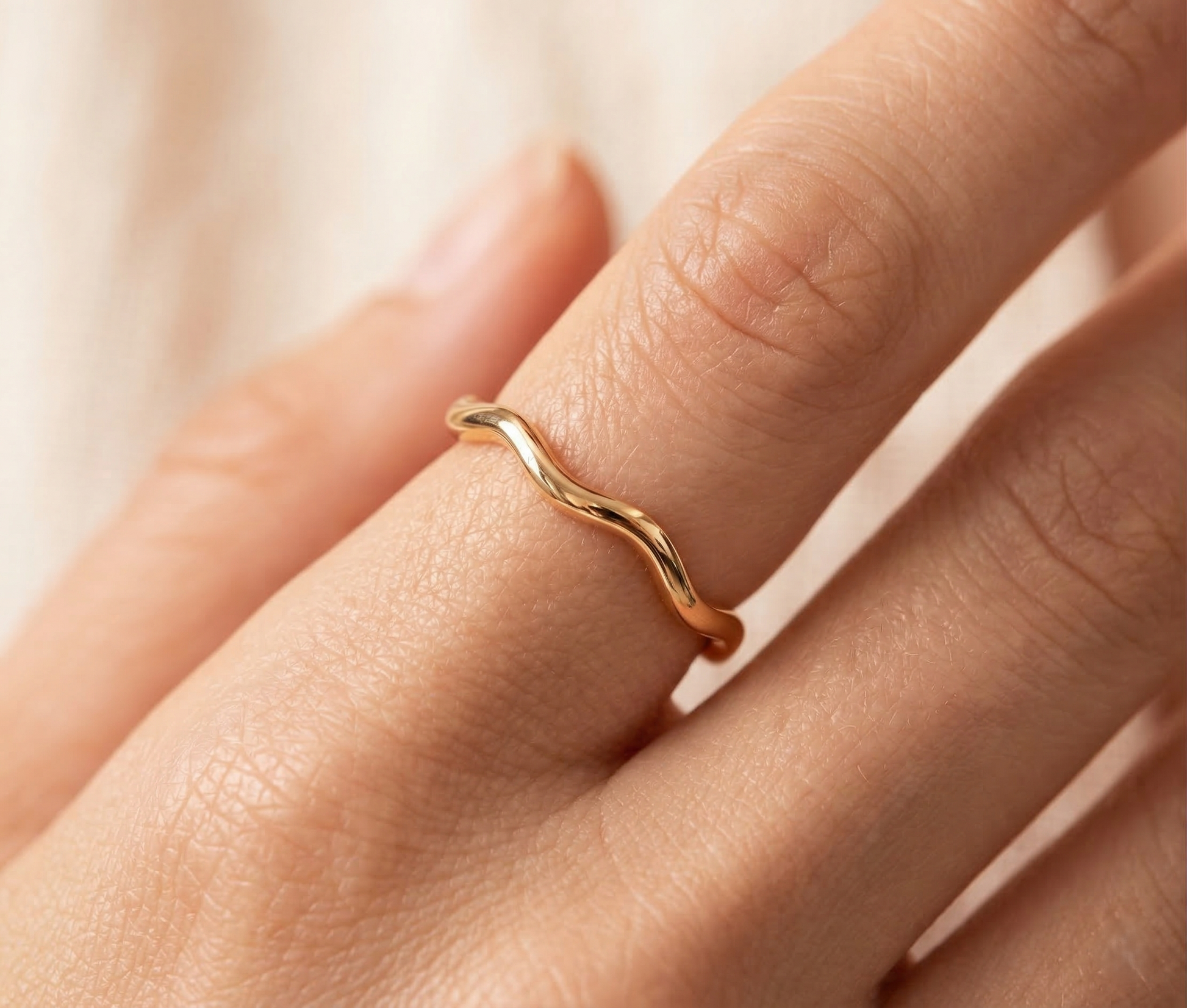 Modelo luciendo el anillo Giulia dorado, un anillo fino de acero resistente al agua con formas orgánicas