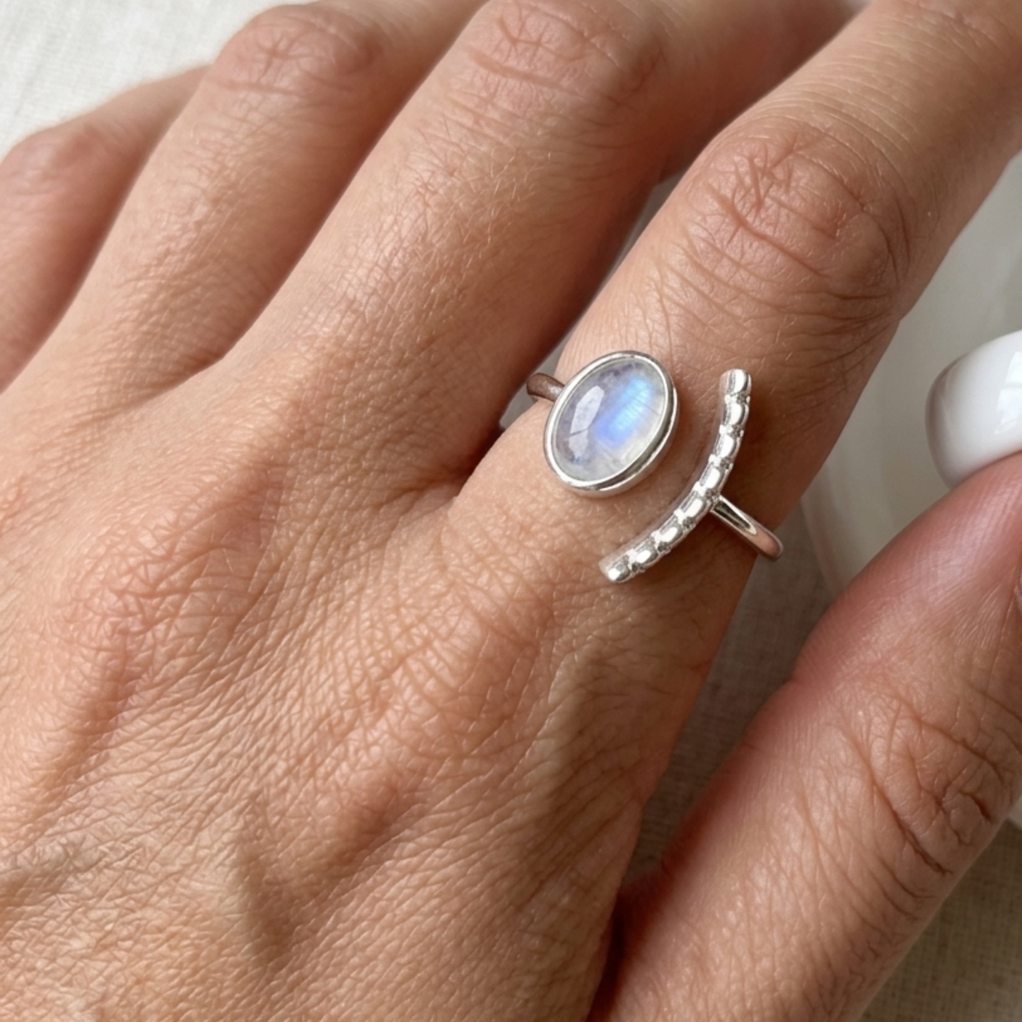 Modelo luciendo anillo NAÏS de plata con piedra luna natural