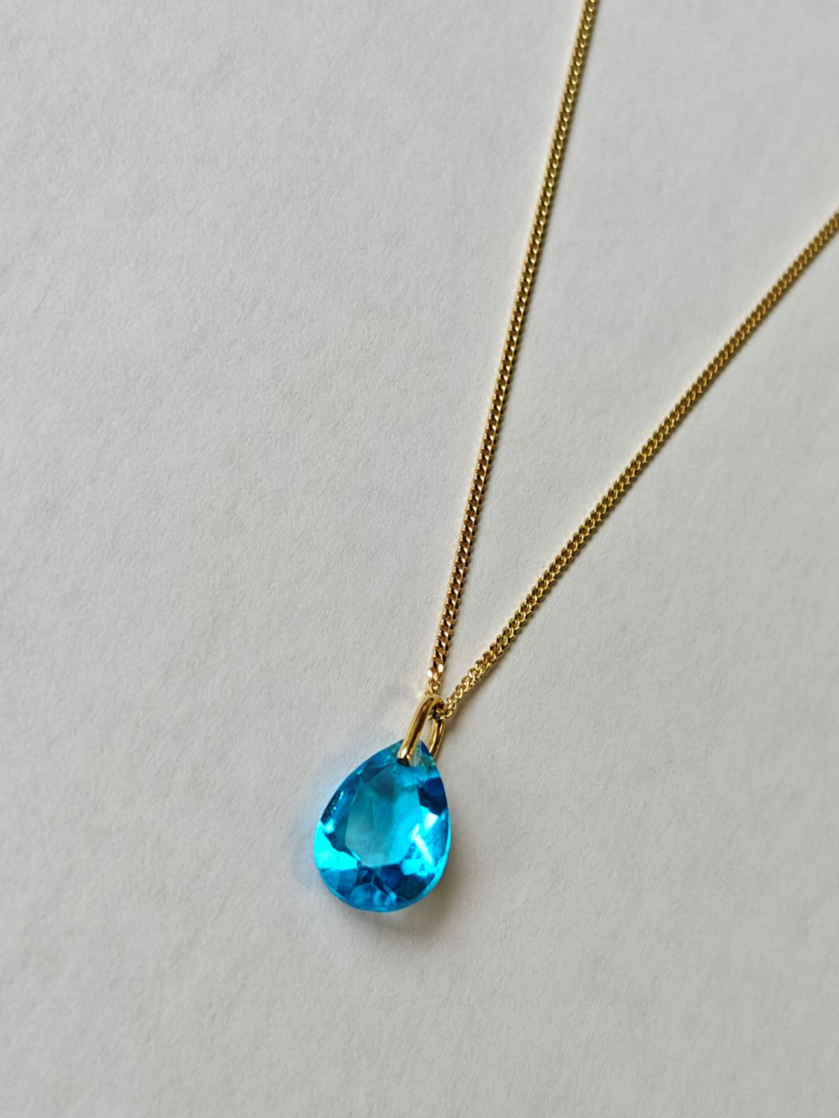 Collar de plata bañado en oro de 18 quilates con diseño sutil y colgante de topacio azul natural brillante