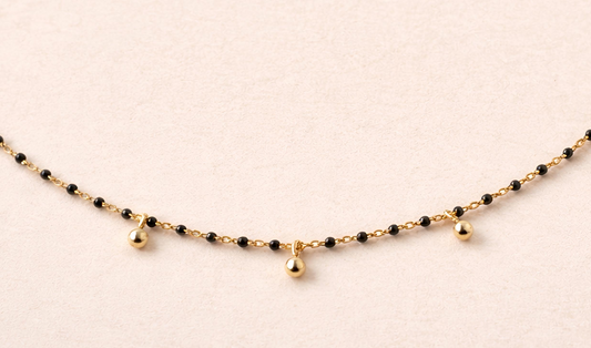 Collar Nocturne en Plata de Ley 925 con baño de oro de 18k y piedras naturales de ónix negro de MALBAE.