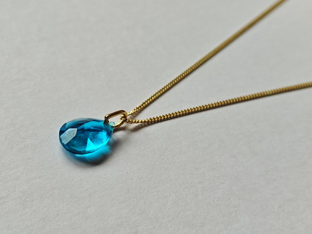 Collar Malbae de la línea Pure en plata de ley 925 con baño de oro de 18k y colgante de topacio azul natural