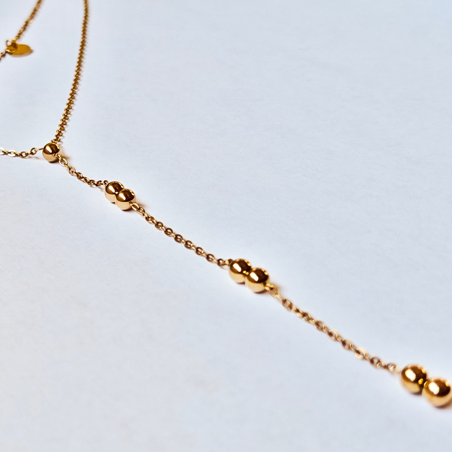 Detalle de las esferas del collar VELIA de acero inoxidable bañado en oro