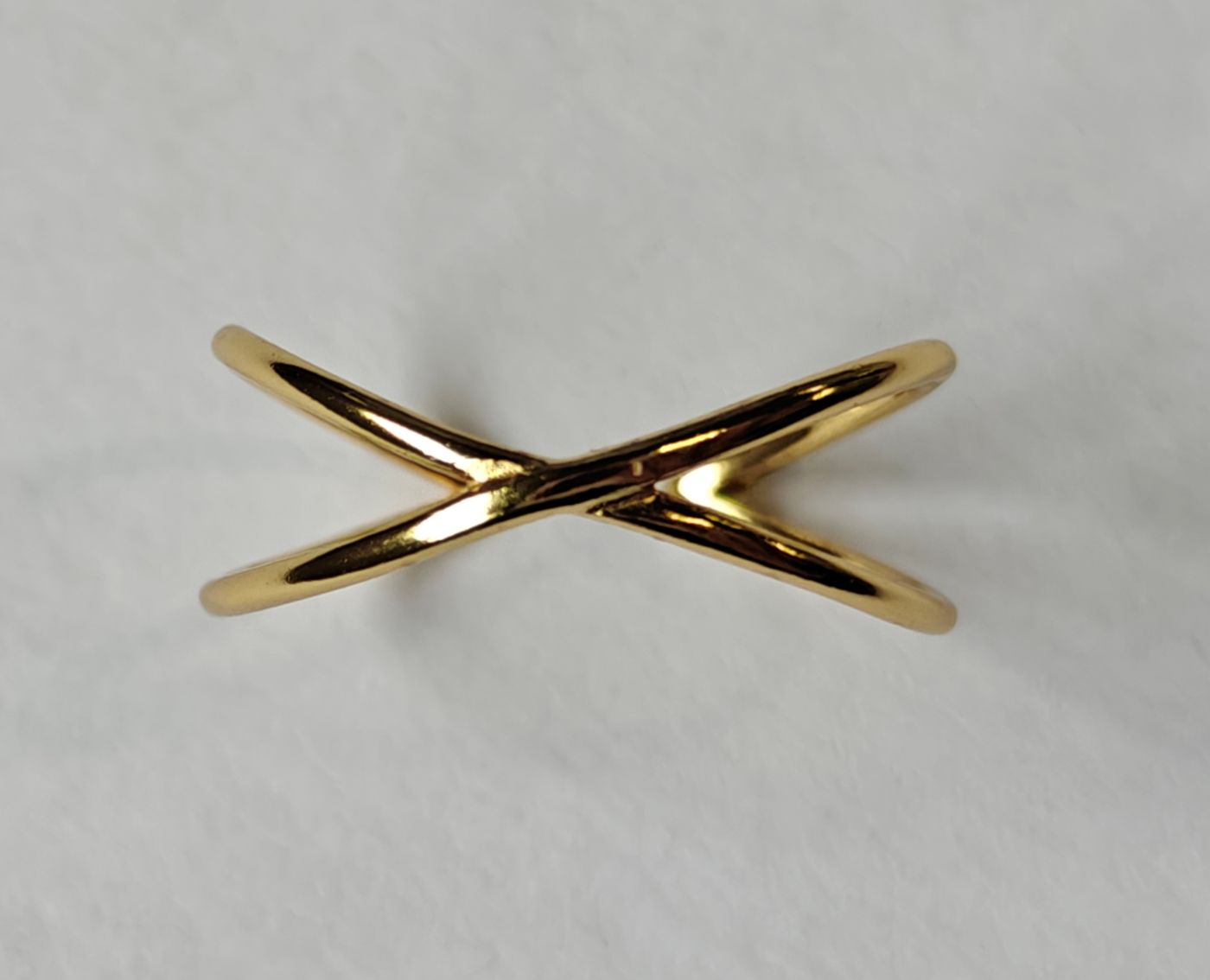 Primer plano del anillo Infini bañado en oro, mostrando la intersección de los aros y su acabado pulido.