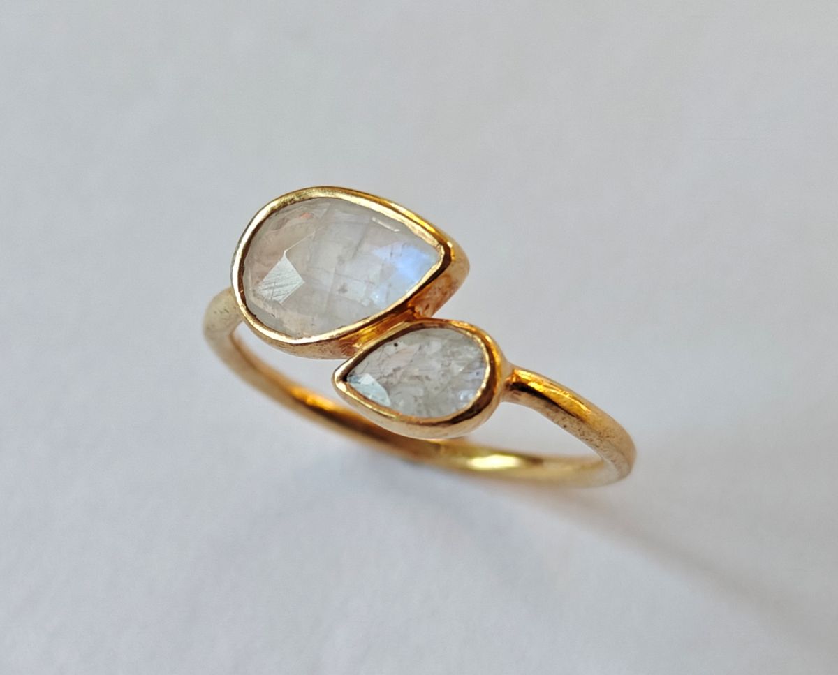 Primer plano de las piedras naturales de piedra luna del anillo Reverie, reflejando su brillo y formas únicas