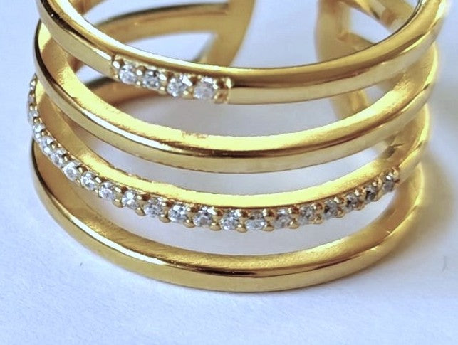 Primer plano de las circonitas engastadas sobre las bandas del anillo ajustable de plata de ley 925 bañada en oro del anillo de MALBAE.