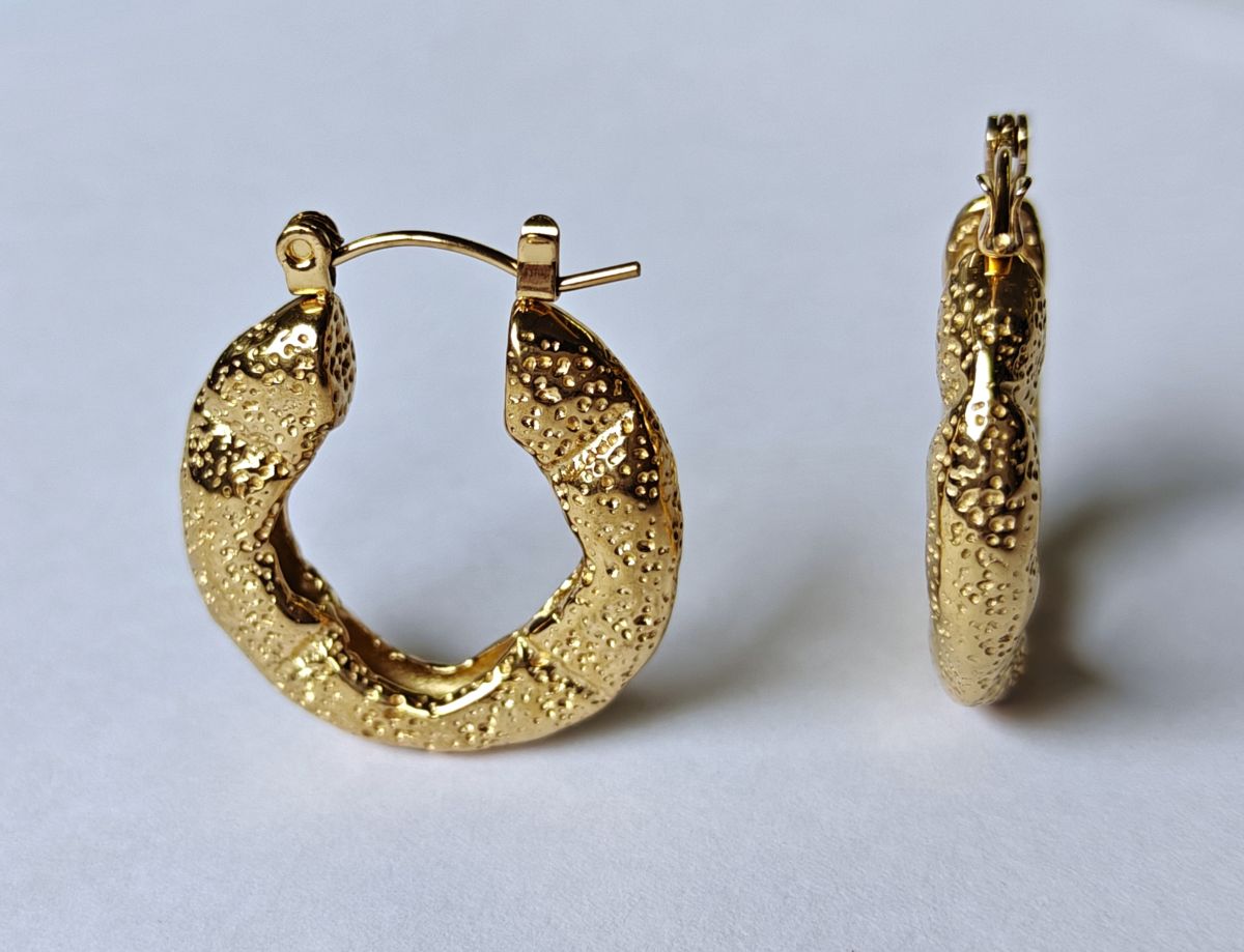 Pendientes de aro Roccia de acero inoxidable waterproof con baño de oro de 18k y textura martilleada. Joyería resistente al agua de MALBAE.