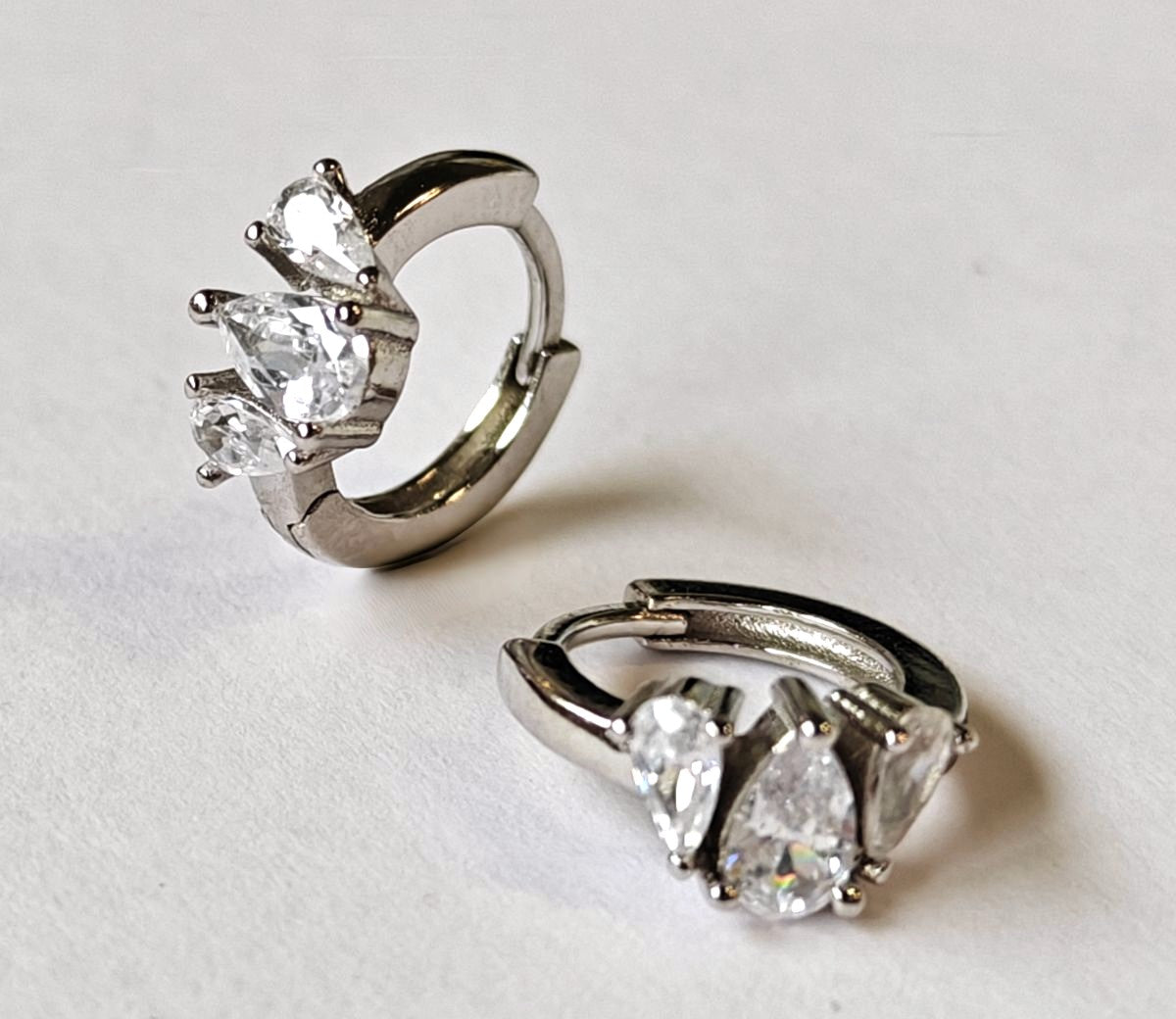 Pendientes de aro pequeños en Plata de Ley 925 con tres circonitas brillantes en formas variadas de MALBAE