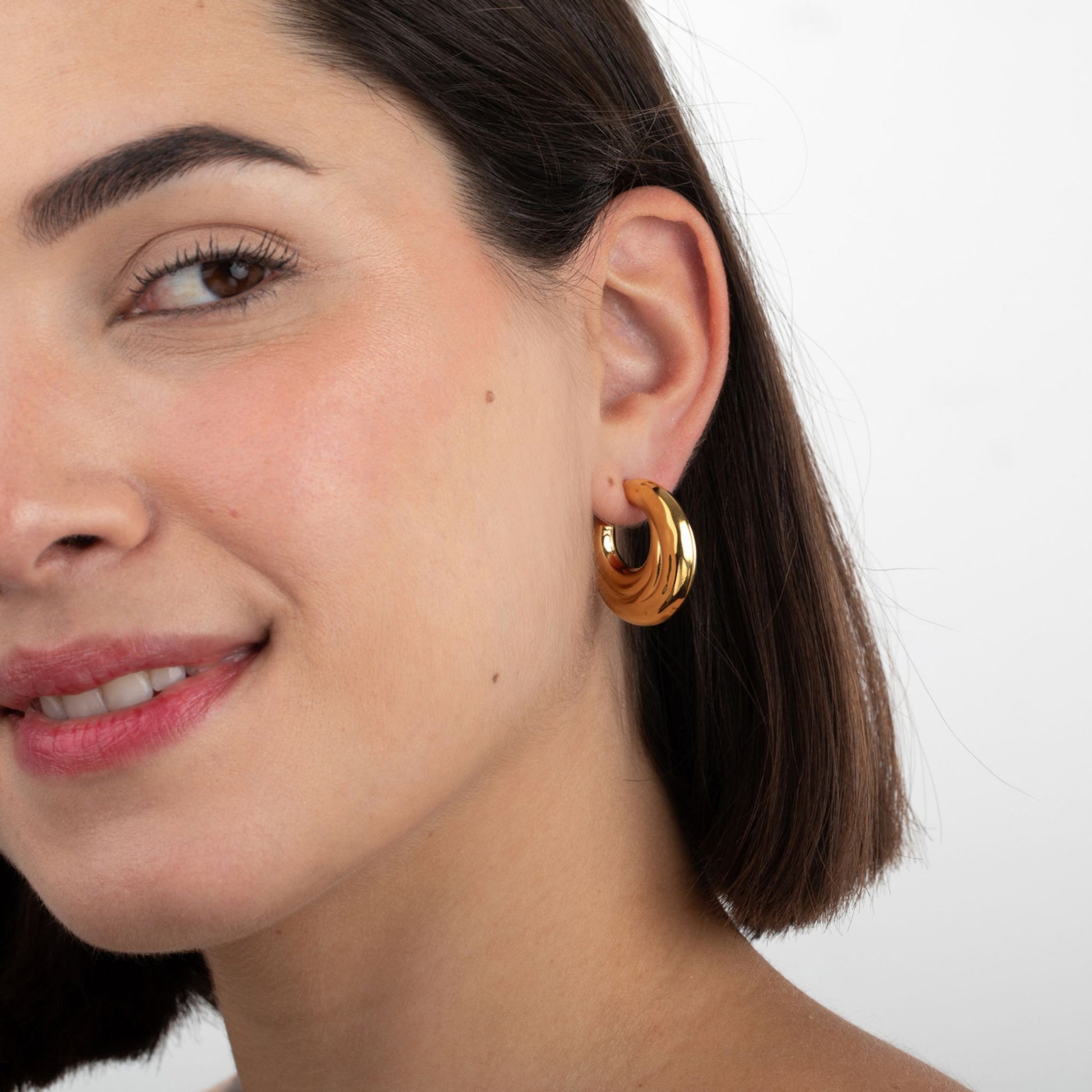 Modelo luciendo pendientes SCIVOLA dorados statement de acero inoxidable oro 18K