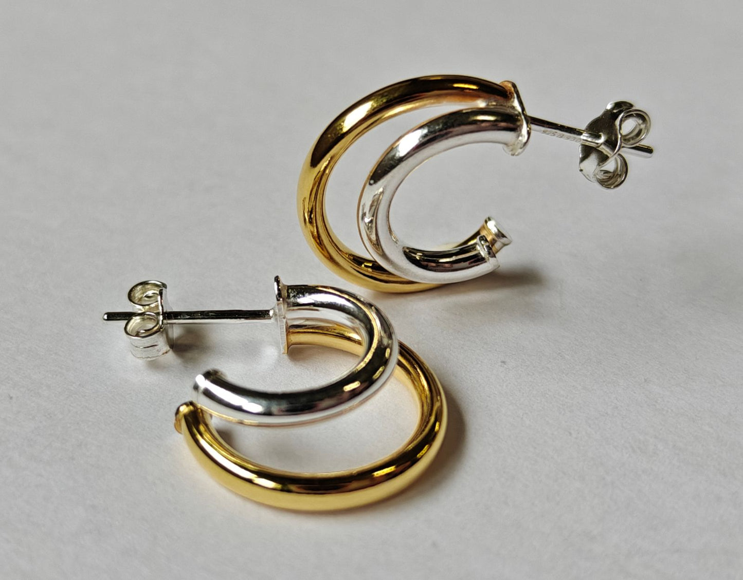 Detalle acabado dorado y plateado de pendientes de doble aro bitono BINÔME plata 925