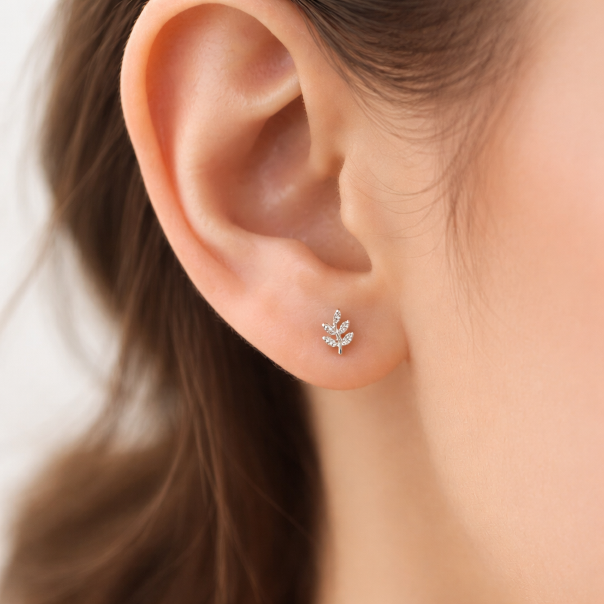 Modelo luciendo pendientes FEUILLE de plata 925 con diseño de hoja en la oreja