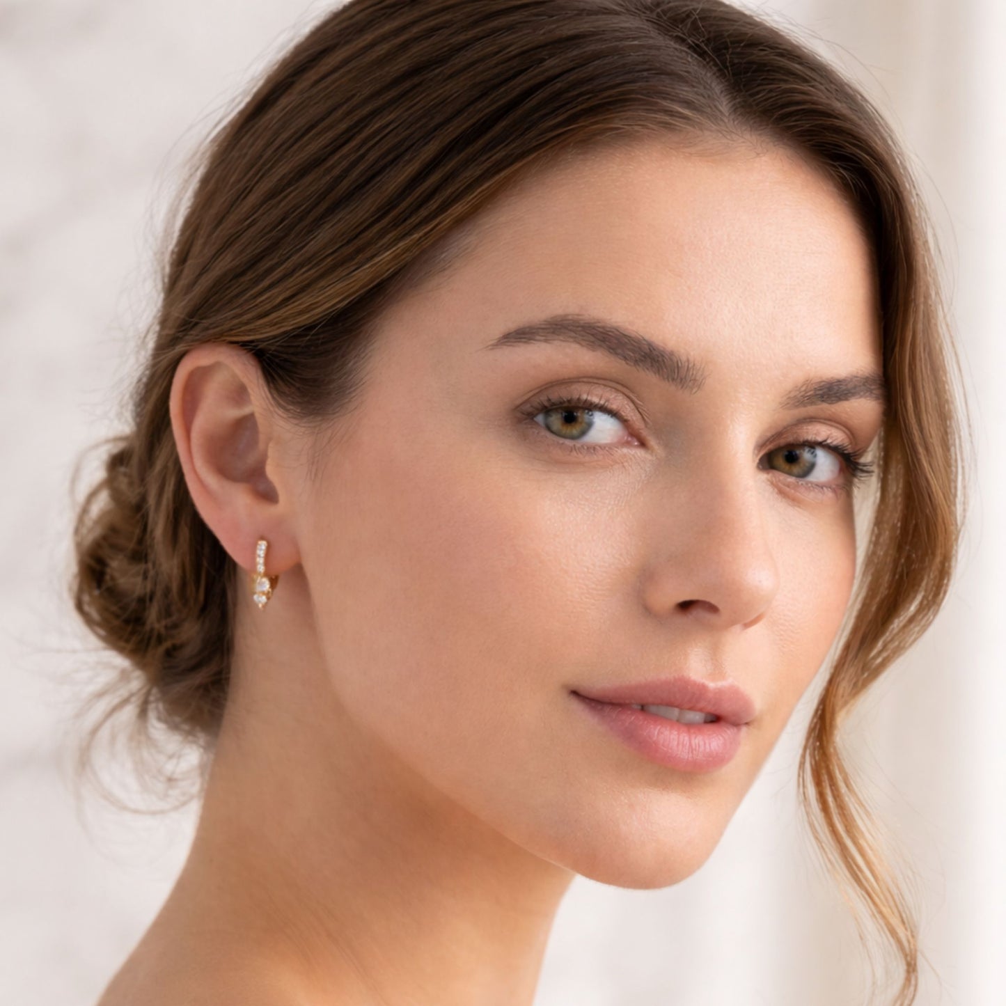 Modelo luciendo pendientes de aro CHETIVE plata 925 bañados en oro 18k con circonitas y charms