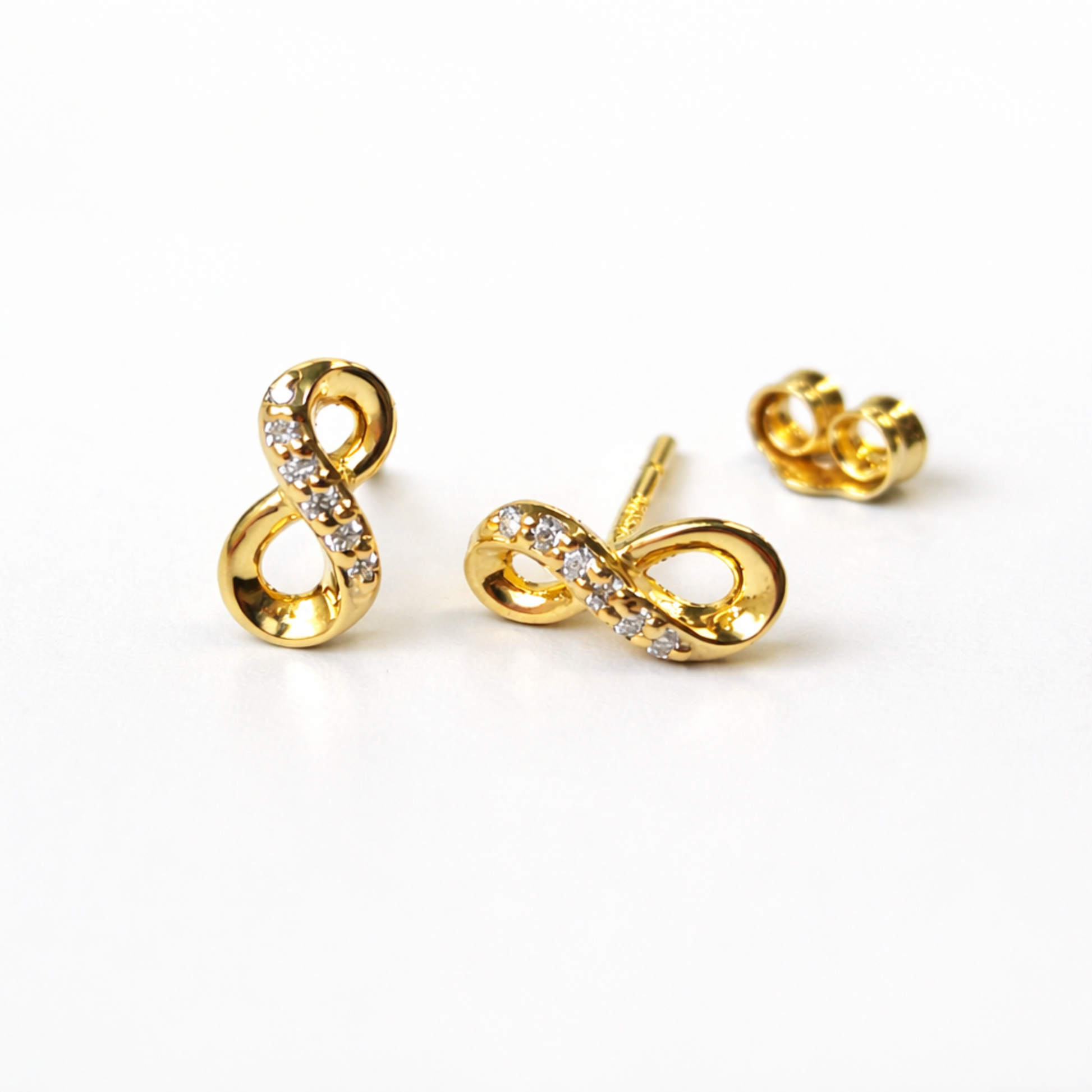 Detalle de pendientes ÉTERNELLE de plata 925 bañada en oro 18K con diseño de símbolo infinito 
