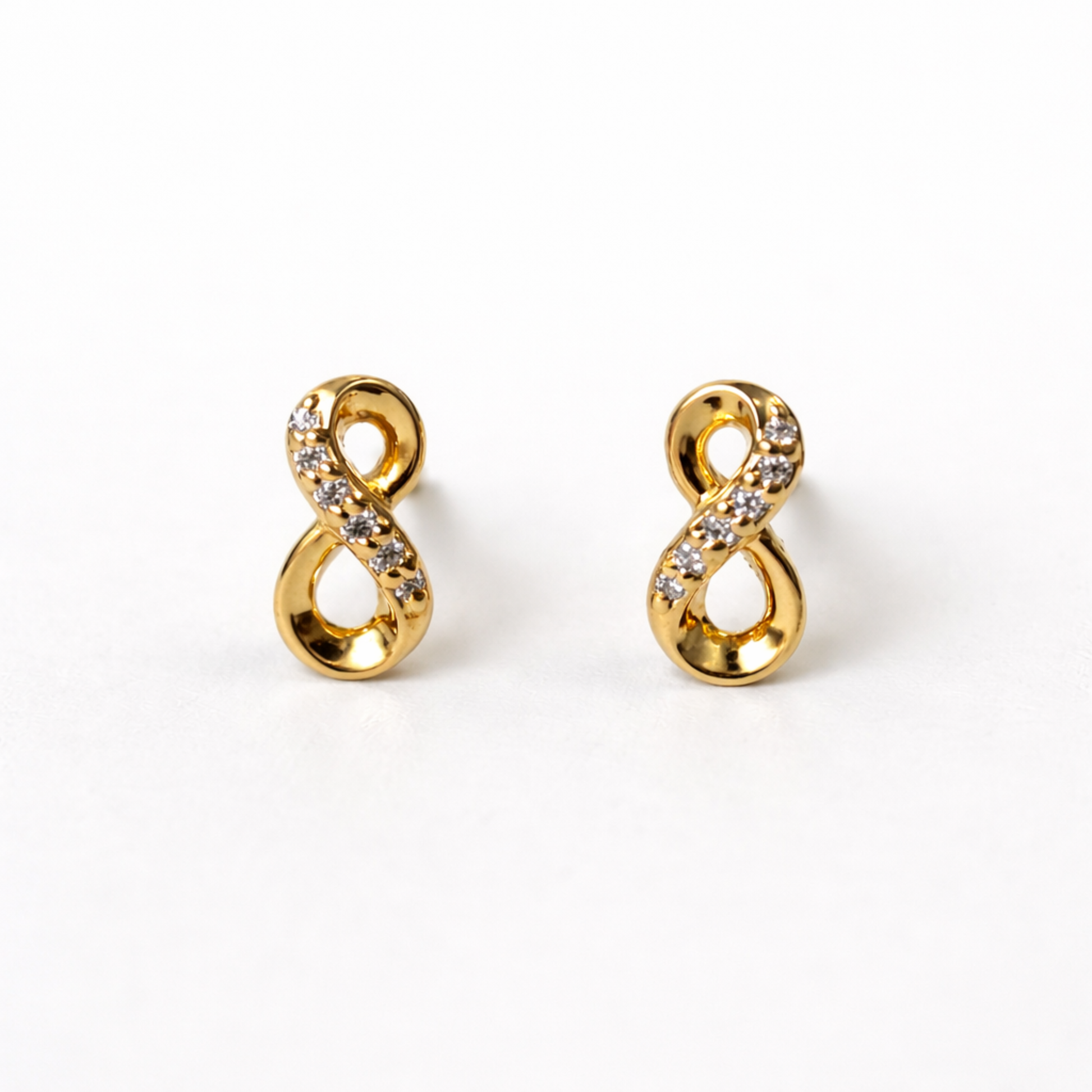 Vista frontal de pendientes ÉTERNELLE de botón diseño símbolo infinito bañados en oro 18K