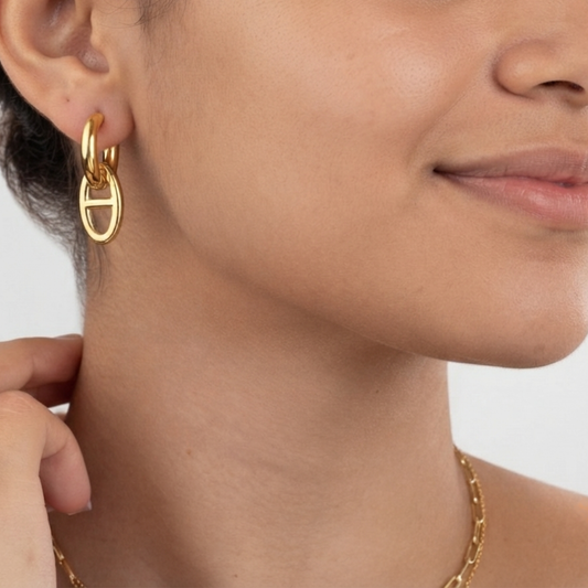 Modelo luciendo pendientes MAGLIA acero waterproof bañado en oro 18K transformables en la oreja 