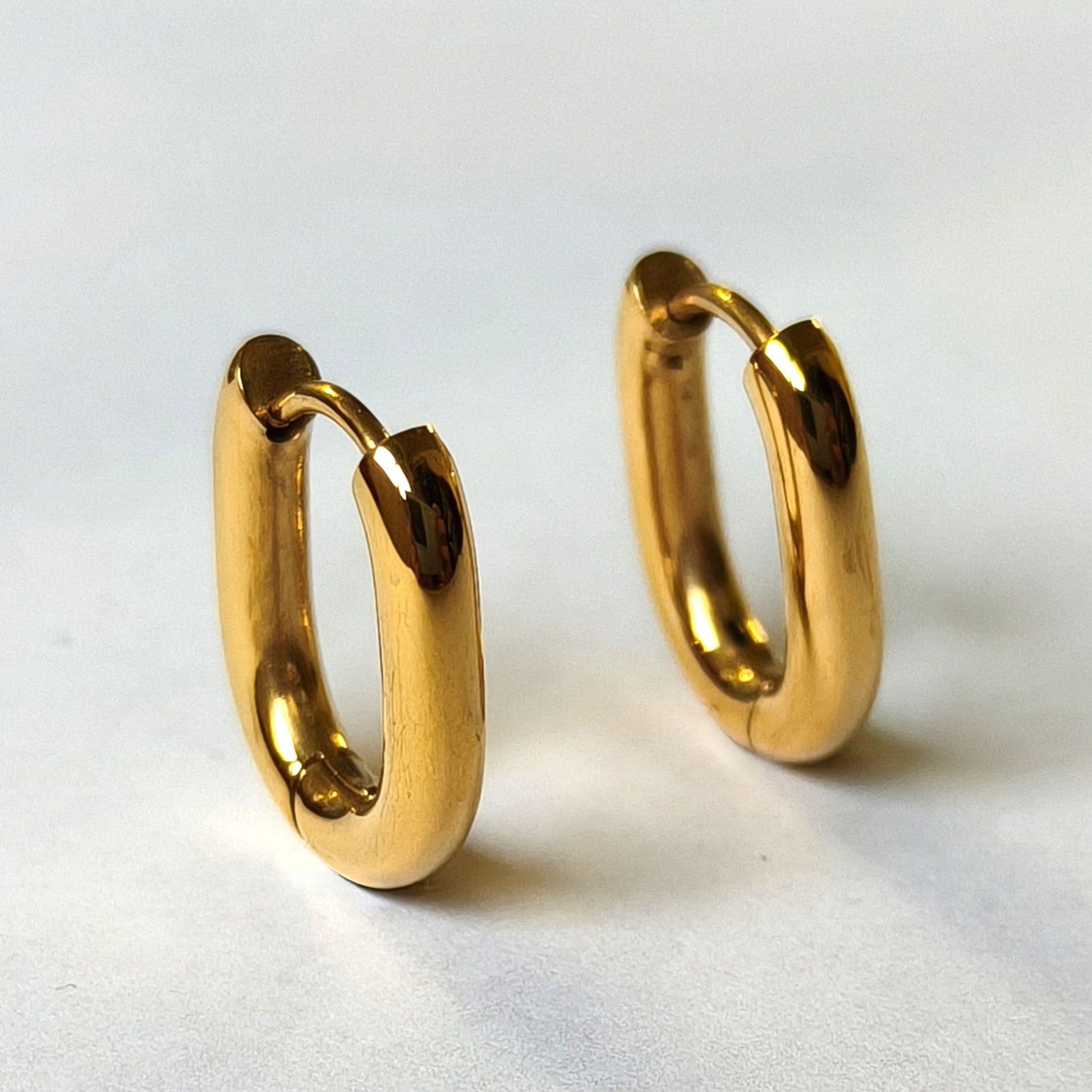 Vista frontal de pendientes OVALE dorados de aro ovalado waterproof
