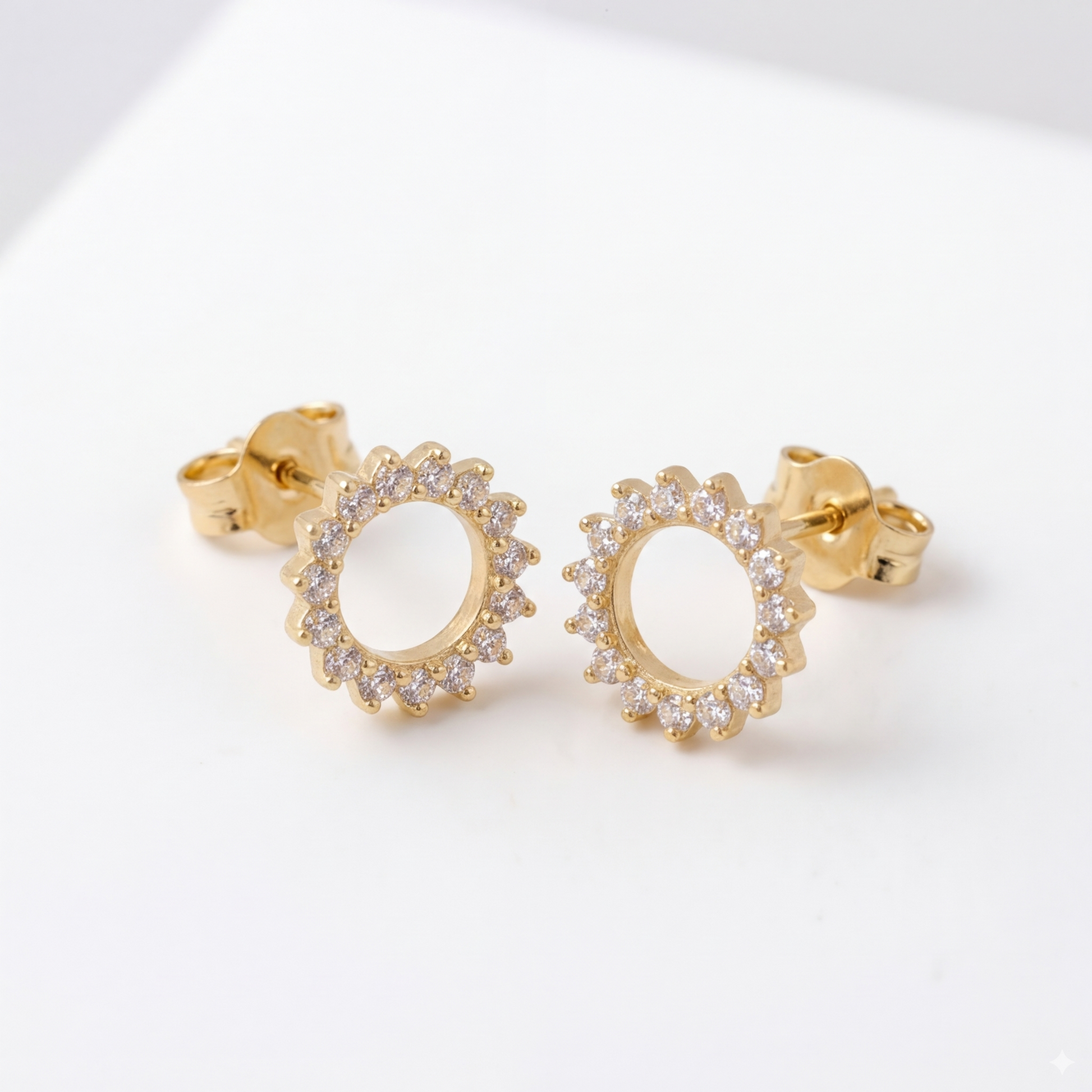 Detalle de pendientes SOLSTICE de plata 925 bañada en oro 18K con diseño de sol y circonitas
