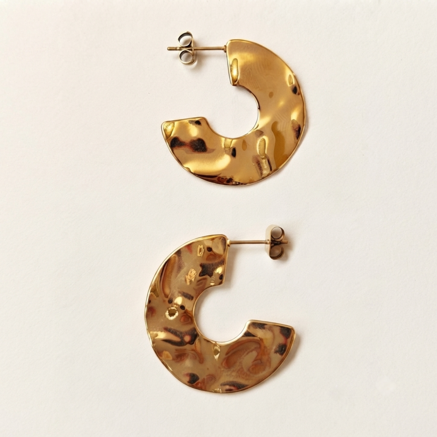 Detalle de pendientes STRUTTURA aro abierto de acero waterproof bañados en oro 18K con textura martillada