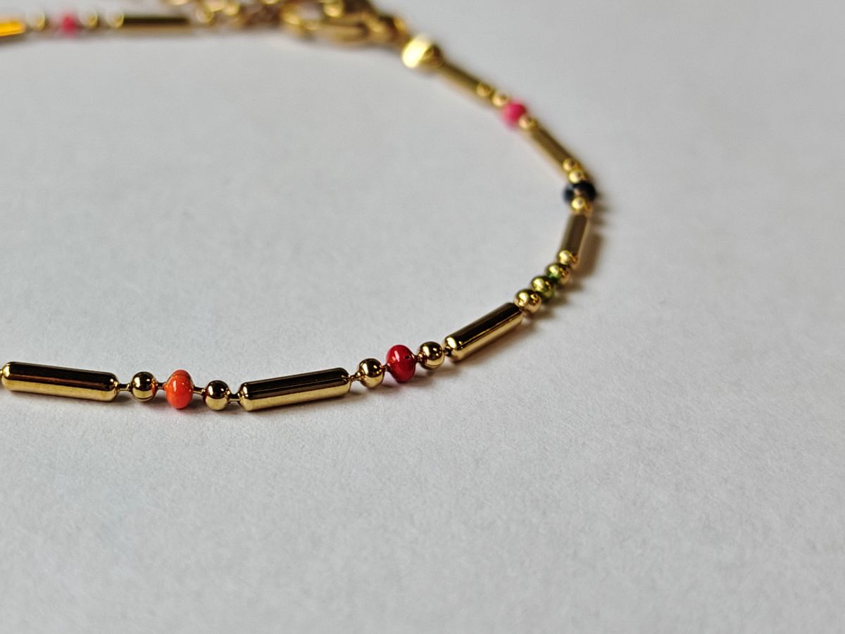 Detalle de pulsera RIVA de acero waterproof bañada en oro 18K con detalles de esmalte multicolor